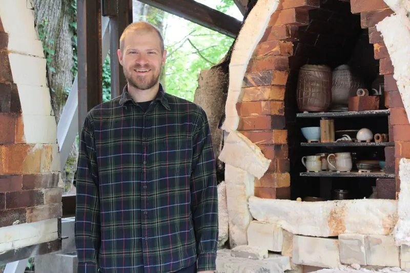 Aaron Filson standing in front of the open soda kiln